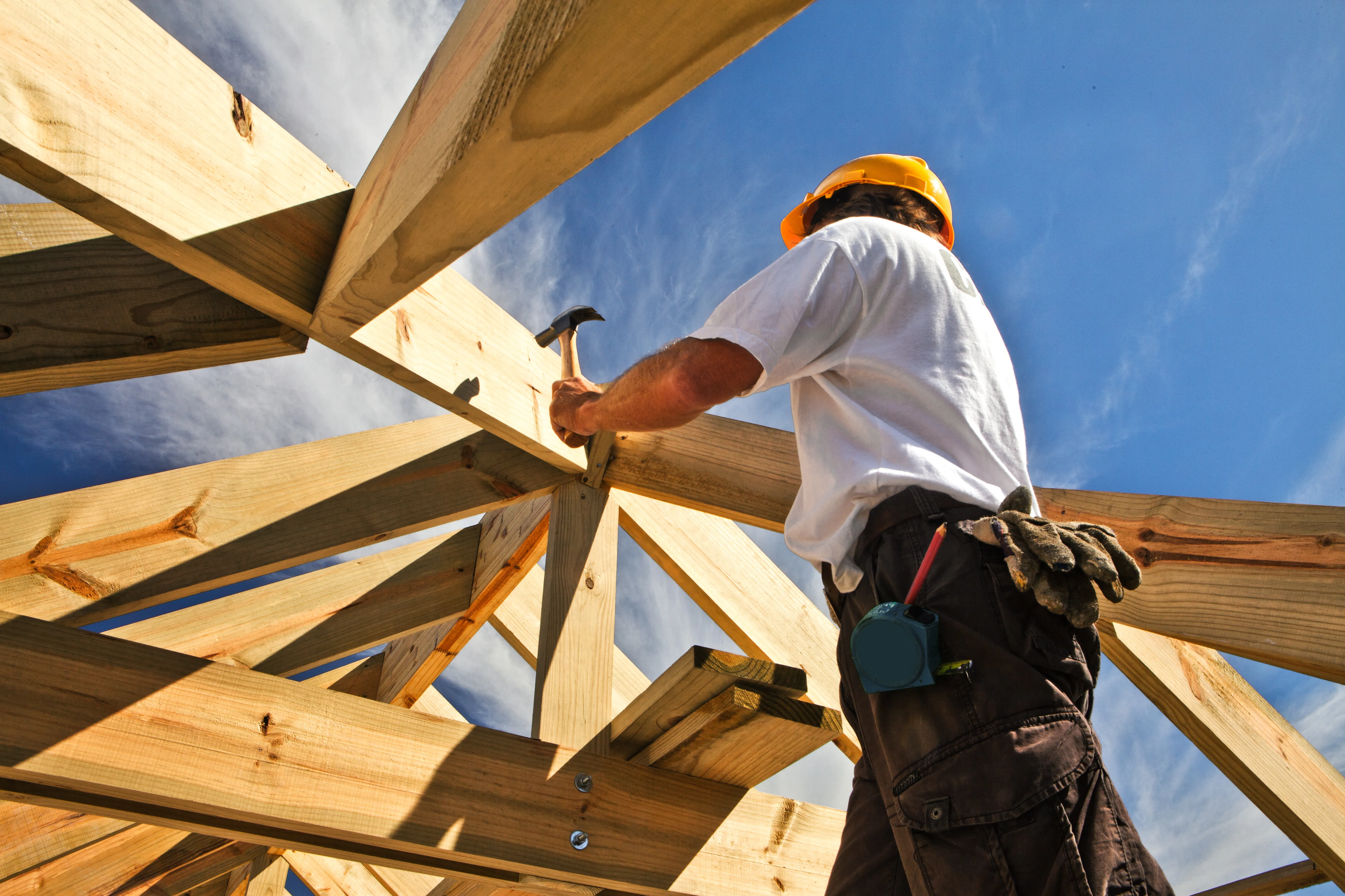 Meșter lucrând la structura unei case